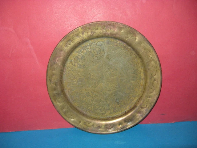 Un antiguo plato persa/árabe de bronce con adornos florales y geométricos...