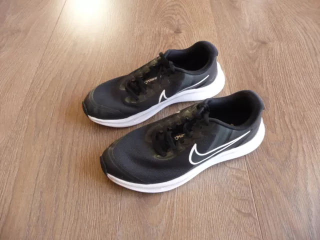 Nike junior boy`s black & white Starrunner trainers size 4