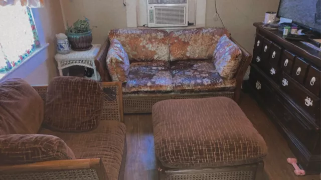 3 piece brown vintage wicker set with floral fabric on the couch