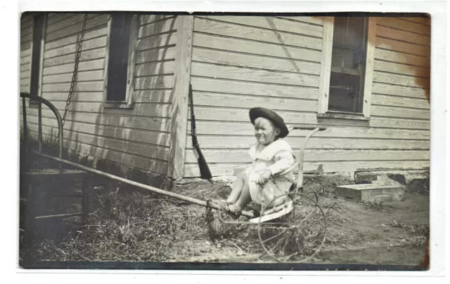 Real Photo Post Card image young child in small two wheeled cart