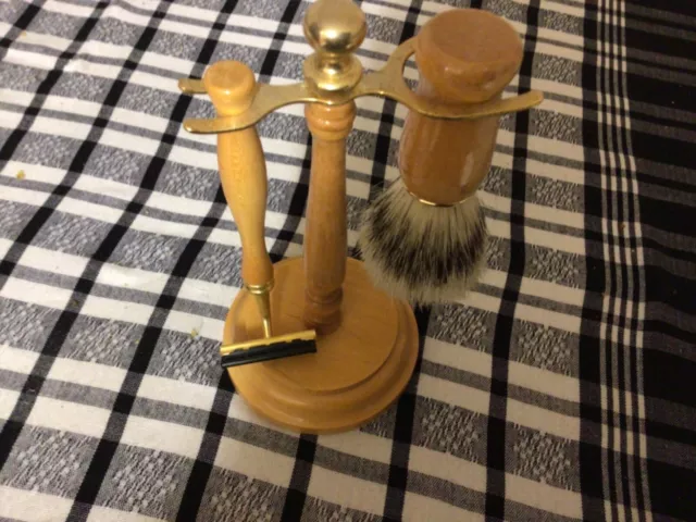 Shaving razor and brush with wooden handles on wooden stand