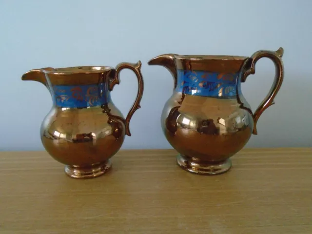 2 Graduated Copper Lustre Jugs with Blue Bands - 14cm and 13cm