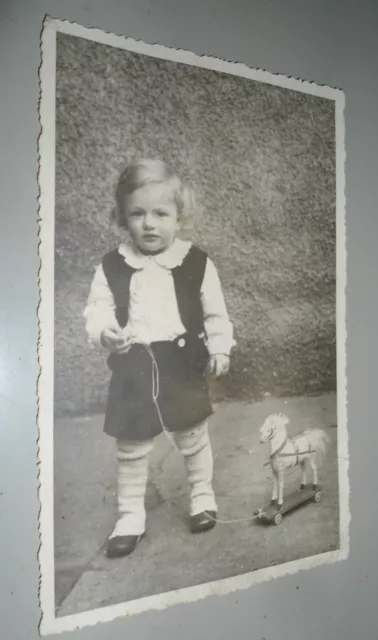 Altes Foto Kind mit Spielzeug, Pferd aus Holz, Kindermode um 1930