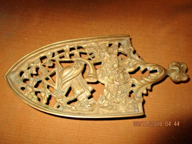 Très joli repose-fer ancien en bronze / décor de fleurs, instruments de musique