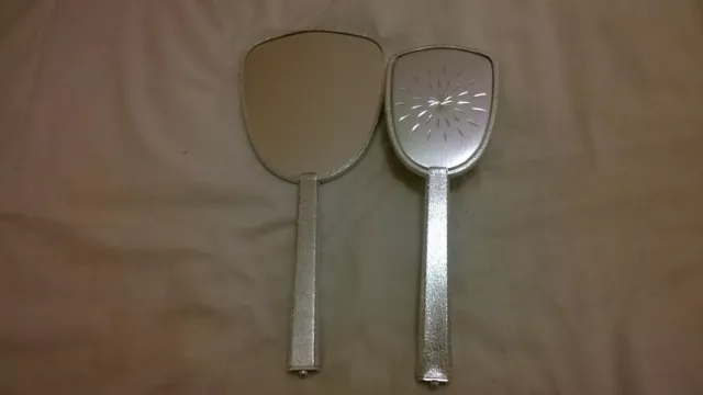 Silver coloured Hand Mirror and brush