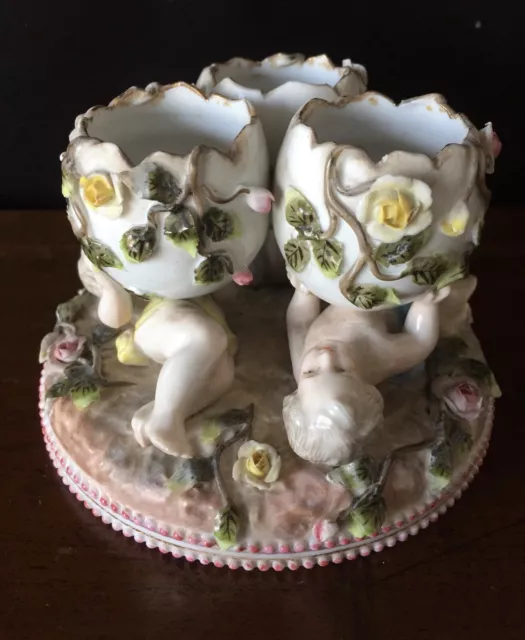 Coquetiers formant un groupe de chérubins en porcelaine