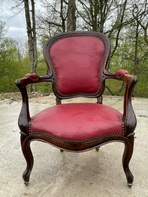 Fauteuil Louis Philippe en noyer et cuir rouge en bon état correct