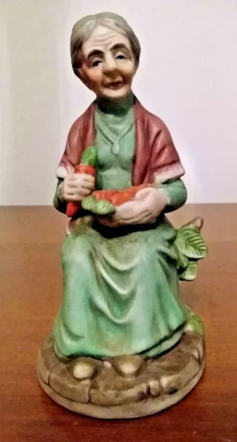 14 Cm High Old Woman Sitting On A Stump With A Bowl Of Carrots Ceramic Figurine