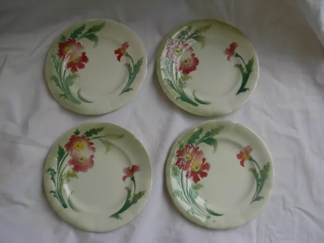 Quatre assiettes anciennes en faience à décor de fleurs.