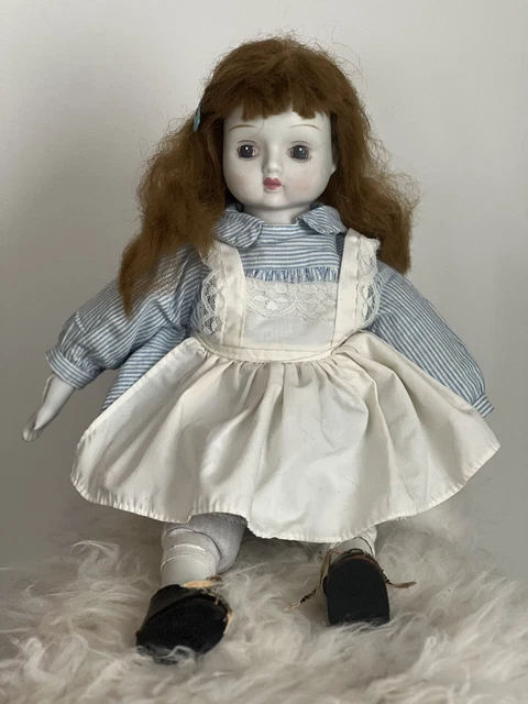 Vintage Porcelain doll, painted face, reddish brown hair.