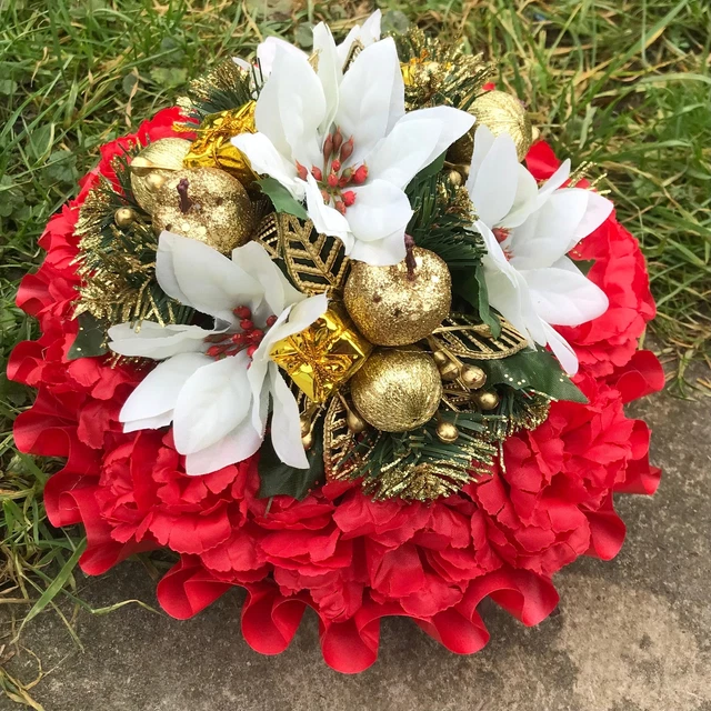 A christmas memorial posy of red roses and carnations