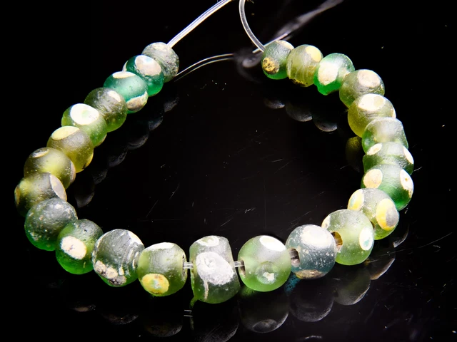 A Short Strand of 25 Ancient Islamic Period Green Evil Eye Beads with Yellow and