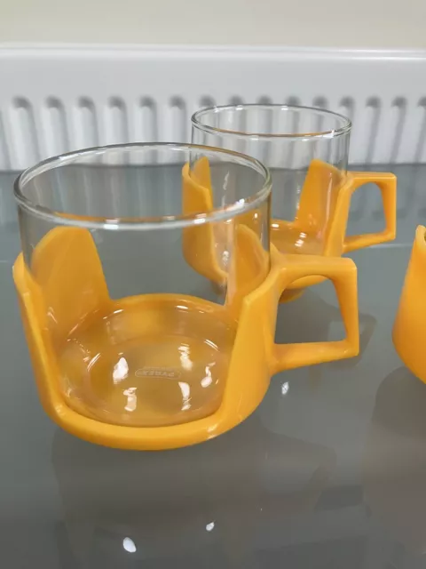 Three Vintage Pyrex Glass Cups In Bright Yellow Plastic Holders