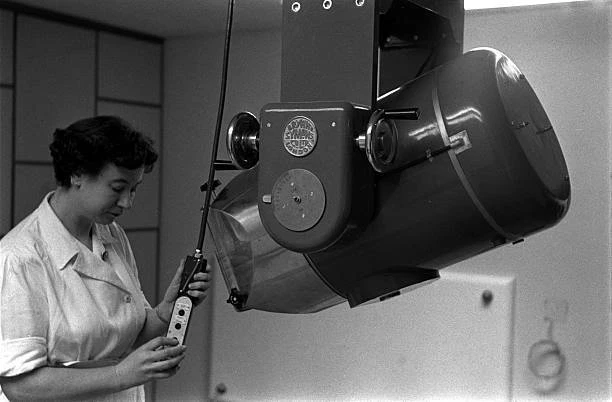 RADIOGRAPHER IS PICTURED adjusting the controls of equipment 1950s Old ...