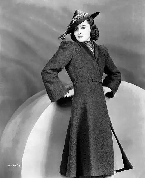 Olivia de Havilland wearing a conical hat and a fitted coat 1930 Old Photo