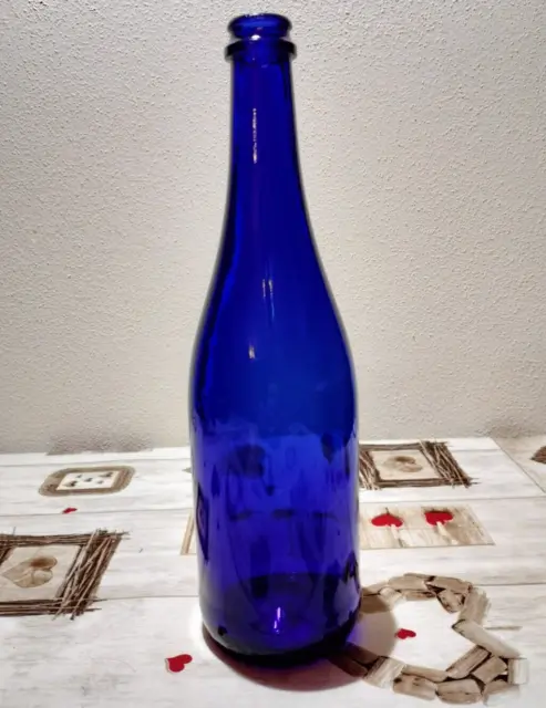 bottiglia vuota in vetro blu con tappo a corona rosso e verde per alimenti vino