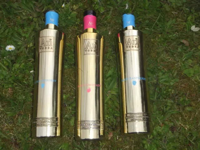 3 Empty shiny gold coloured 'Au'Vodka Empty bottles.1 with top.Bar throws