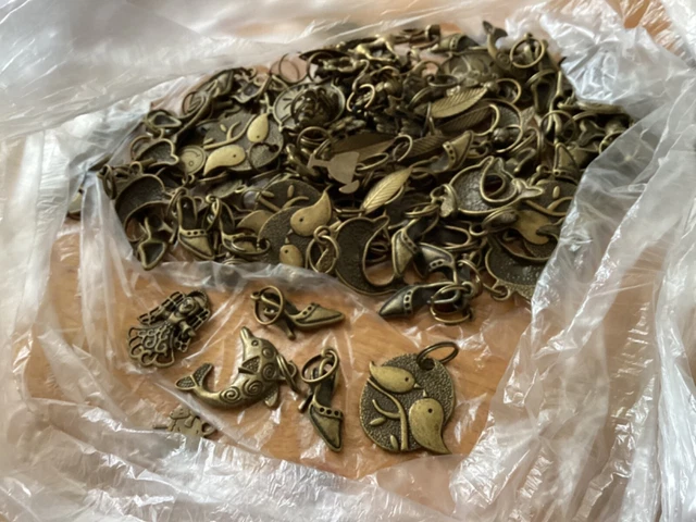 JOB LOT OF CRAFTING CHARMS APPROX 100. Brass coloured metal (13)