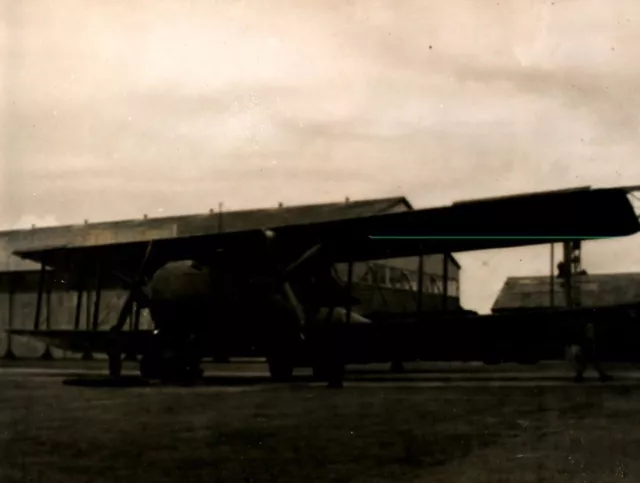 Postcard RPPC biplane aircraft coming out of hanger on airfield c1930 military