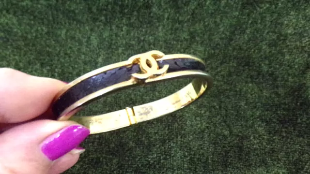 Elegant bracelet logo CHANEL  metal couleur doré, cuir lezard noir BON OCCASION