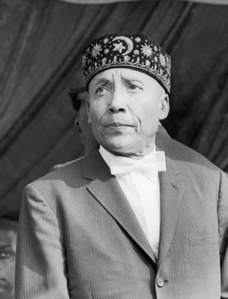 MUSLIM LEADER ELIJAH Muhammad wearing a fez with a pinstriped j - 1965