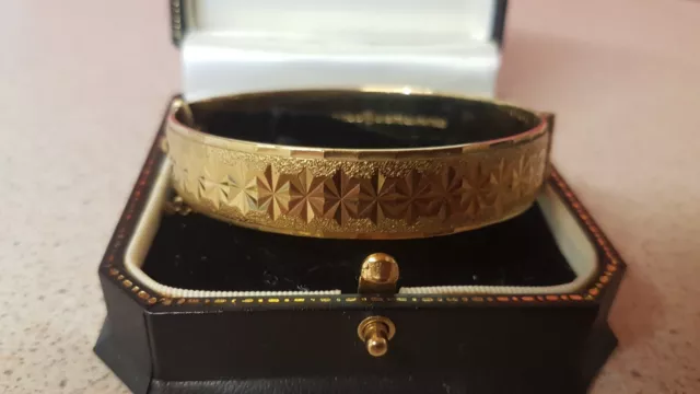 VINTAGE 9CT ROLLED GOLD HINGED BANGLE WITH SAFETY CHAIN, 27.59 Grams.