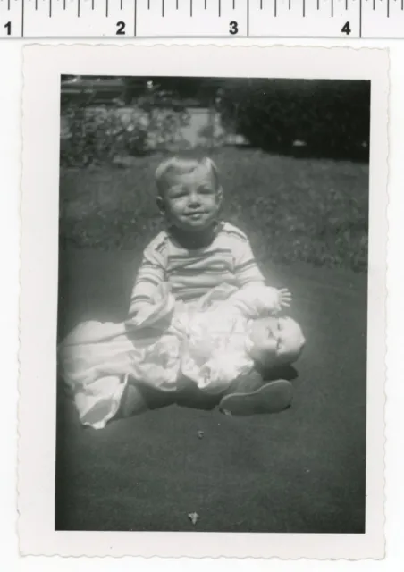 Vintage 1950's photo / Funny Face Toddler Sits on Ground with DOLL Waving at You