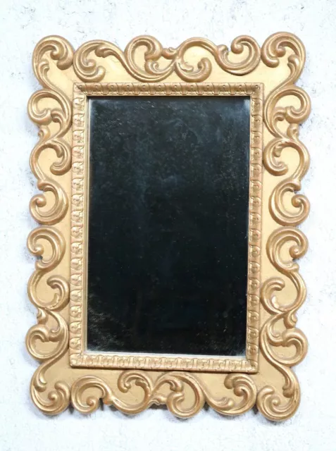 Espejo de pared vintage con marco de madera tallada y dorada.