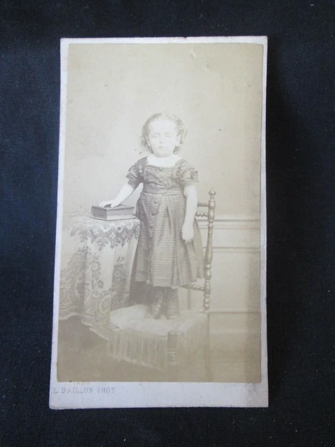CDV Petite fille en pied costumée accoudée sur dossier d'un fauteuil