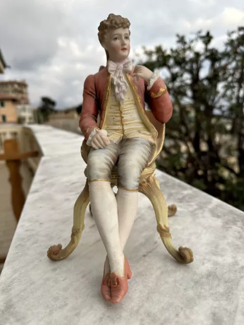 Statua di nobiluomo francese seduto su sedia in porcellana biscuit 700'
