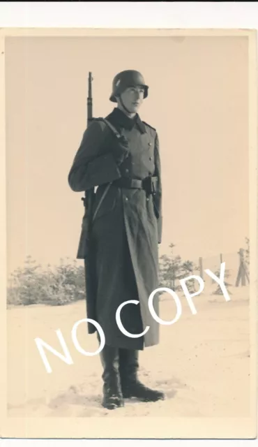 Foto PK WK II, Portrait Soldat mit Gewehr und Uniform Stahlhelm B 1.38