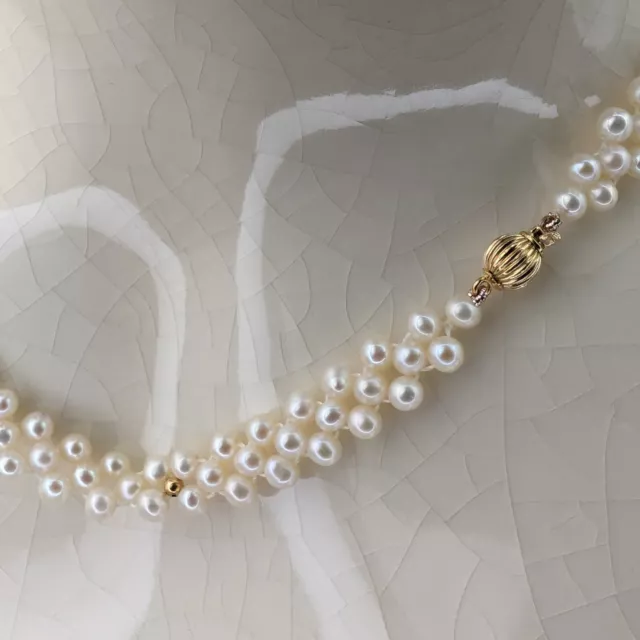 Three-row cross-knotted freshwater seed pearl necklace on 9k gold ball clasp