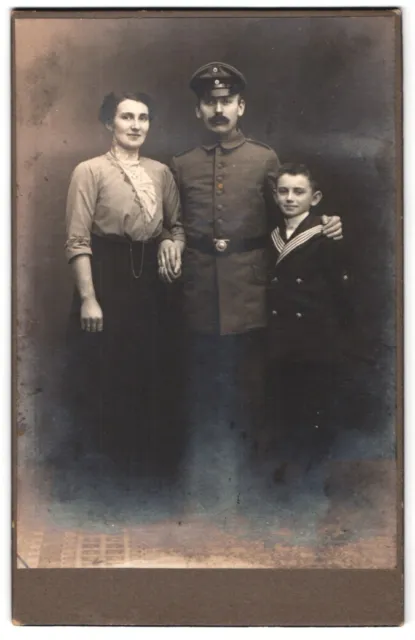 Fotografie unbekannter Fotograf und Ort, Familienportrait mit Mann in Soldatenu