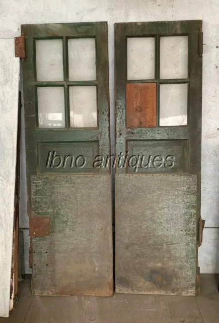 PAIR OF 1940s VINTAGE INDUSTRIAL WOODEN DOORS W/ GLASS PANES AND STEEL PLATES.