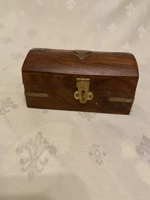 Wooden trinket box created like a treasure chest with brass inlay. Latch fitted.