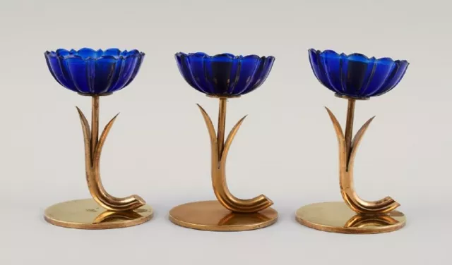 Gunnar Ander for Ystad Metall. Three candlesticks in brass and blue art glass