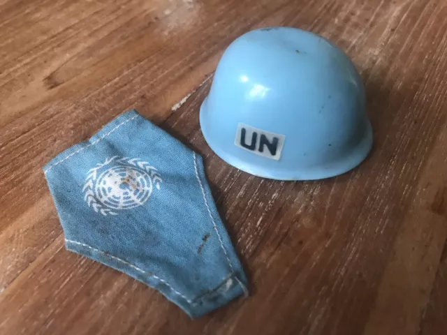 RARE ORIGINAL 1960's TOMMY GUNN UNITED NATIONS HELMET WITH STRAP & U.N .ARM BAND