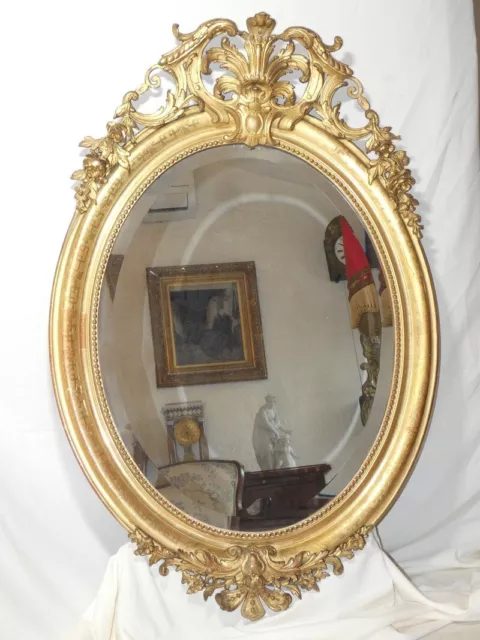 Miroir doré ovale à fronton d'époque Restauration , 1825 tain biseauté  mercure