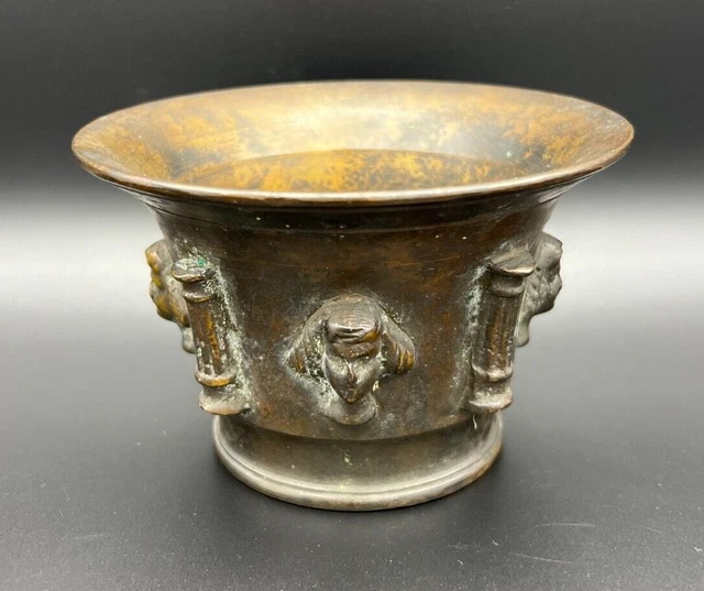 An Antique Spanish 17th century brass mortar decorated with 4 faces