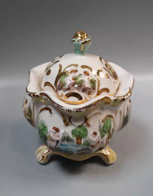 Rare ornate Capodimonte footed pot with lid, embossed cherub design, gilt detail