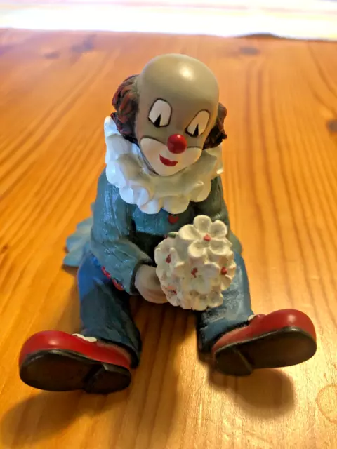 Blumenfreund Gilde Clown sitzend mit Blumenstrauß