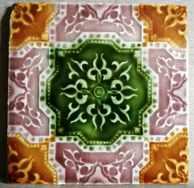 A richly glazed 6"sq early 20th century relief-moulded ceramic tile