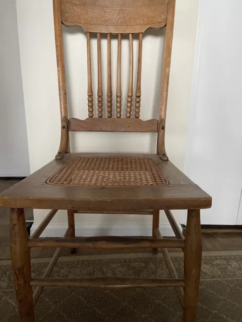 antique wooden spindle carved back chair with cane seat.