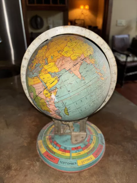 very old tin world globe? atlas holding it up , base has calendar and astrology