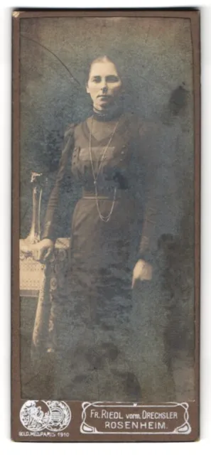 Fotografie Fr. Riedl, Rosenheim, Brünette Dame mit Halskette im schwarzen Kleid