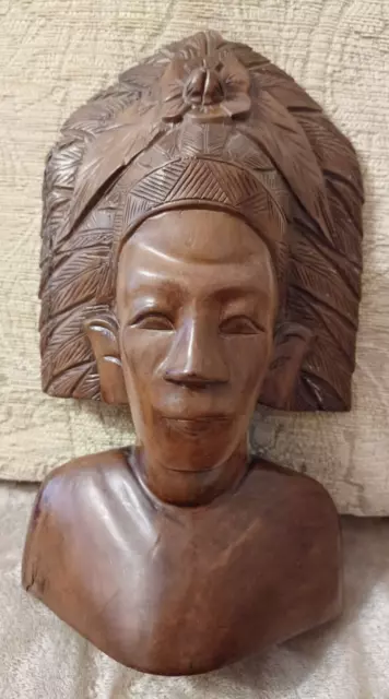 Hermoso vestido de madera tallado de tribal nativo con cabeza de pluma