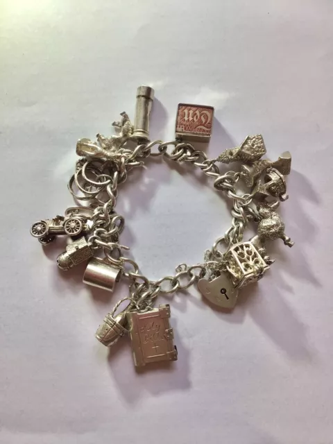 Vintage silver charm bracelet with 16 charms.