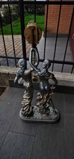 orologio a pendolo su statua