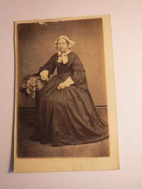 seated old woman in mature skirt with hood - backdrop circa 1860s / CDV
