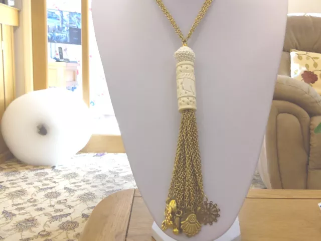 Brand new long antique look 3 chain necklace holding an ivory look pendant